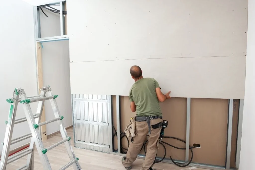 Man installing plasterboard for a room
