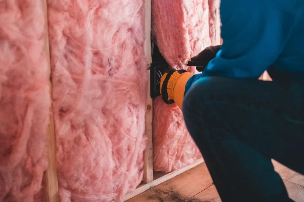 Man installing wool insulation