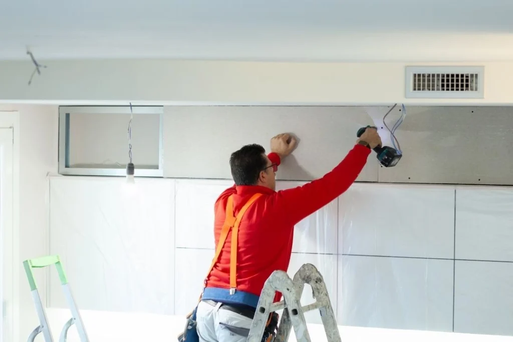 Plasterer installing plasterboard in the kitchen